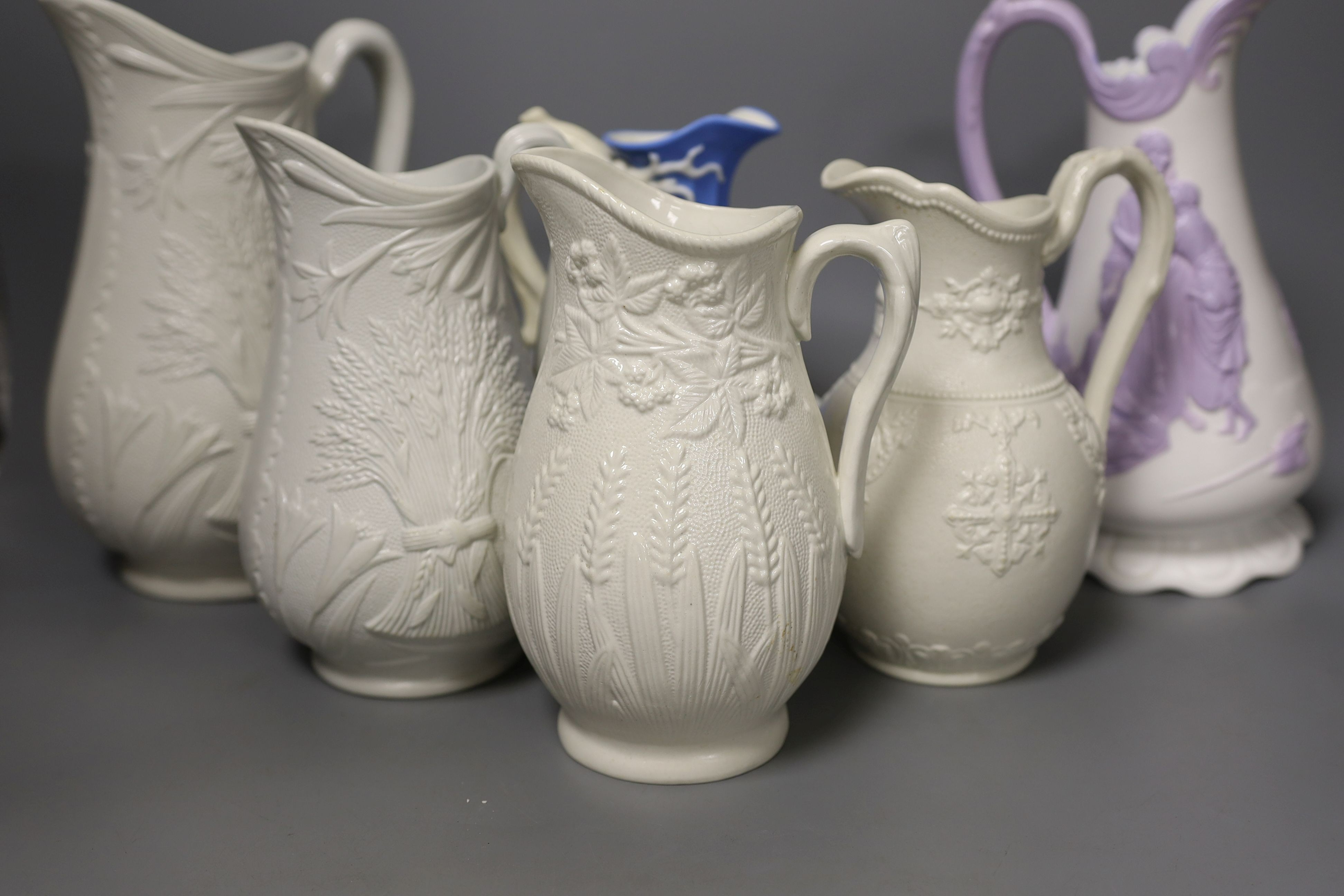 A collection of twelve Victorian relief moulded jugs